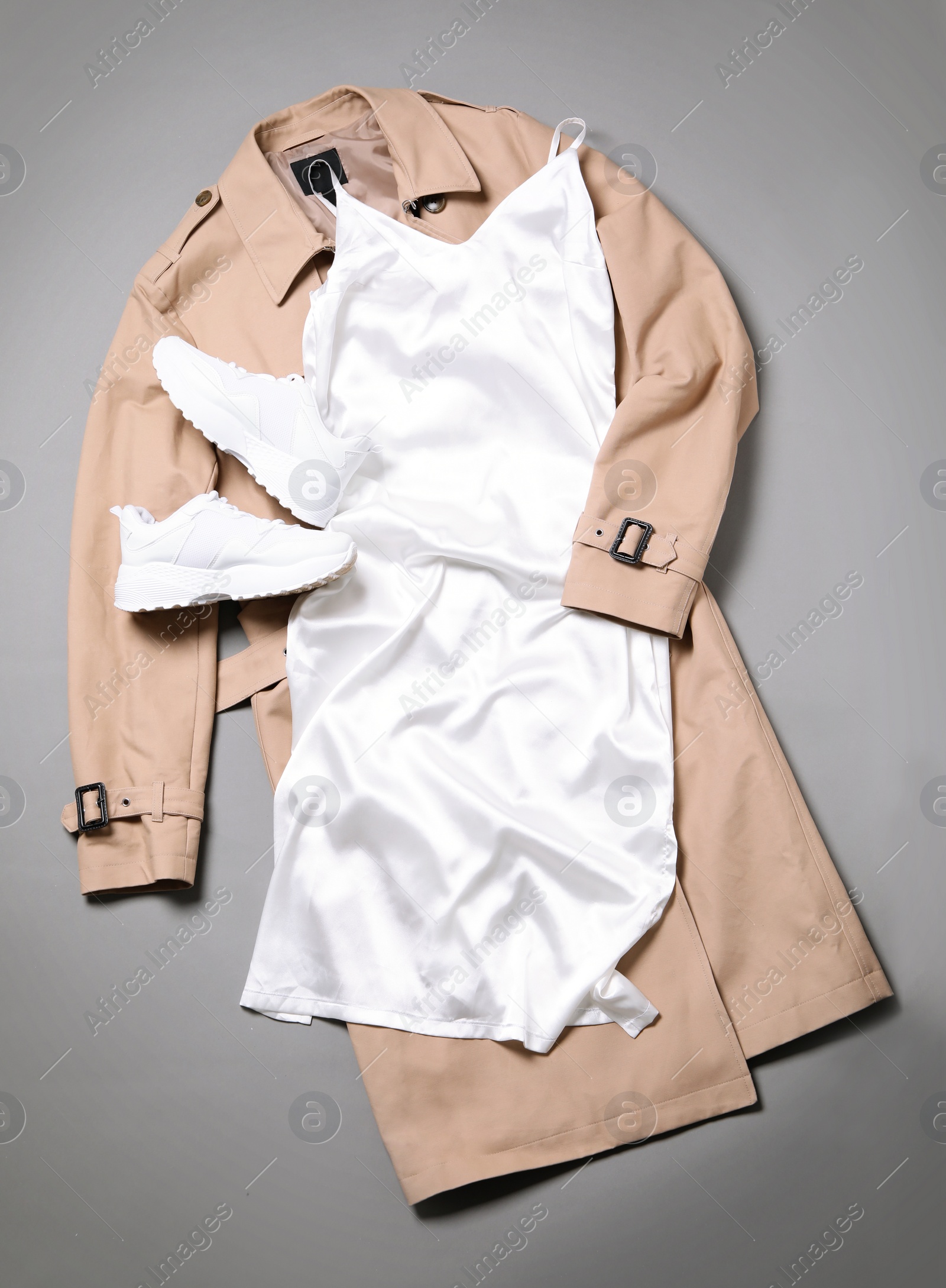 Photo of Stylish white dress and coat on grey background, flat lay