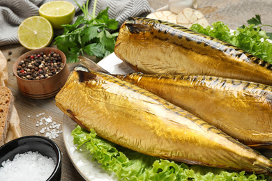 Tasty smoked fish served on wooden table, closeup