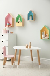 Photo of Children's room interior with house shaped shelves and little table