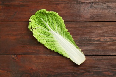 Photo of Fresh leaf of Chinese cabbage on wooden table, top view. Space for text