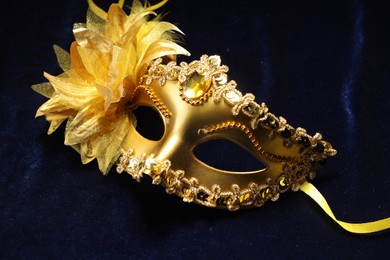 Photo of Theater arts. Golden venetian carnival mask on blue fabric