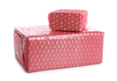 Cardboard boxes packed in red bubble wrap on white background