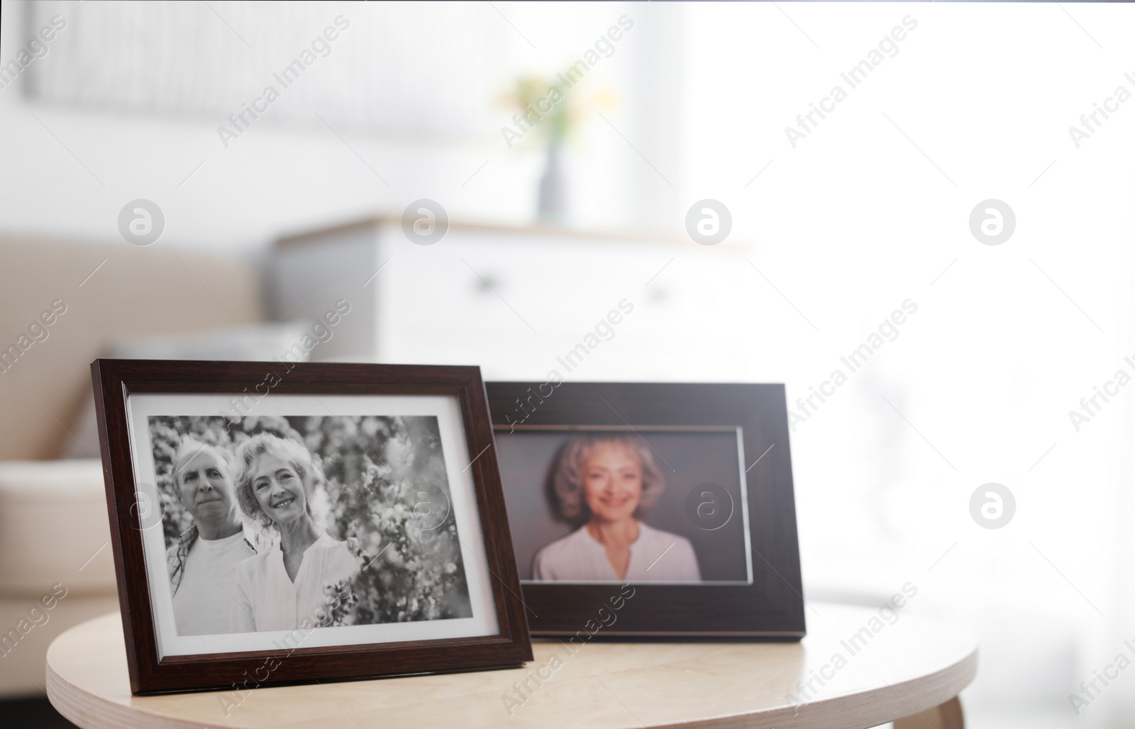 Photo of Portraits in stylish frames on table indoors