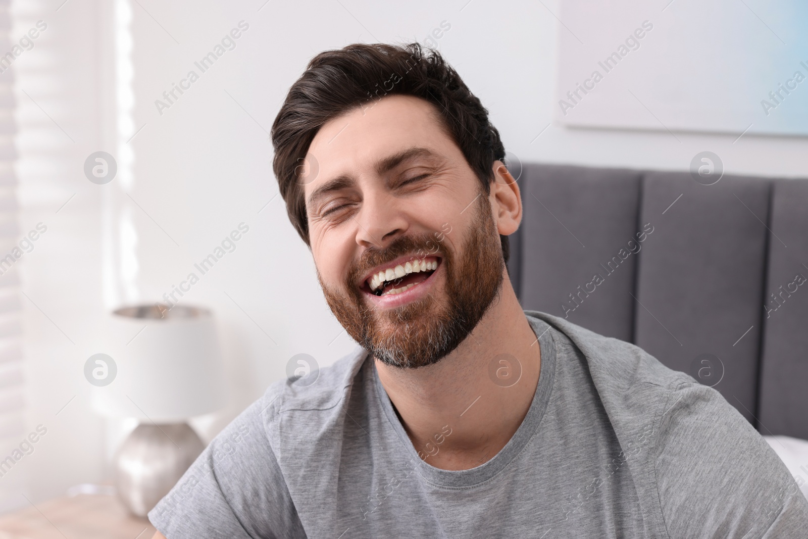 Photo of Portrait of handsome man laughing at home