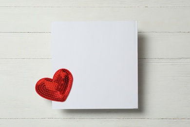 Photo of Blank card and decorative heart on white wooden background, top view with space for text. Valentine's Day celebration