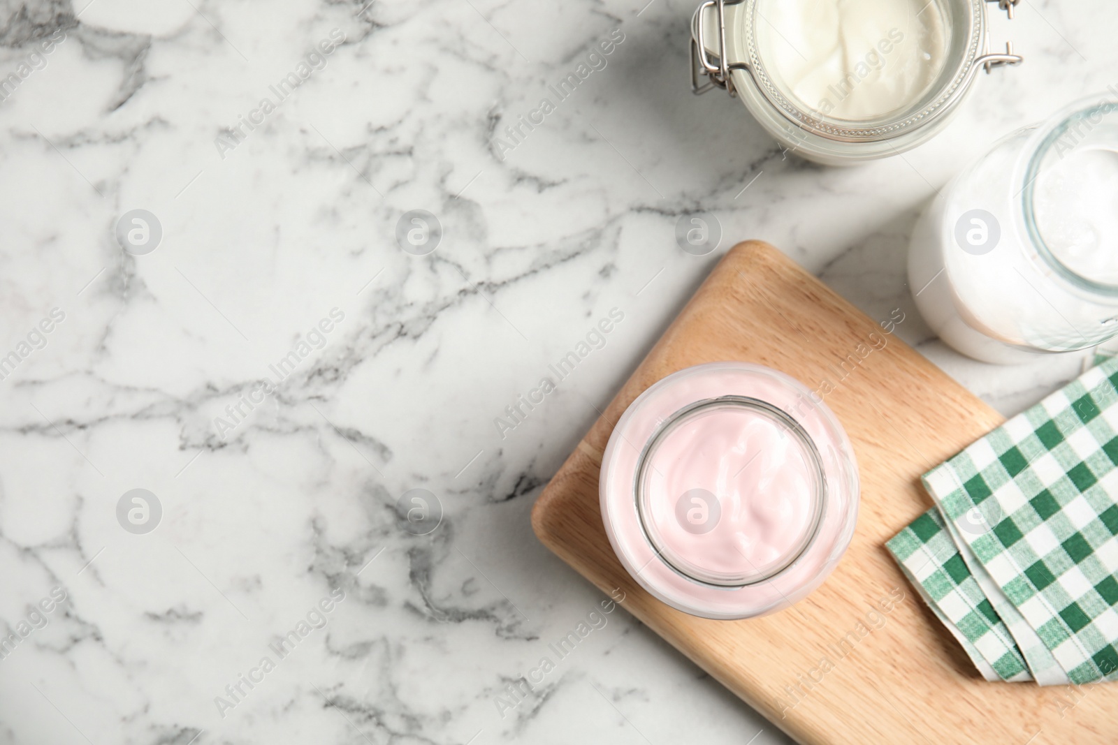 Photo of Flat lay composition with yogurts on marble background. Space for text