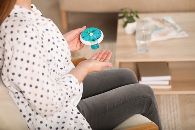 Photo of Pregnant woman taking pill from container at home, closeup