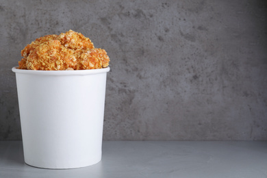 Photo of Bucket with yummy nuggets on grey table, space for text
