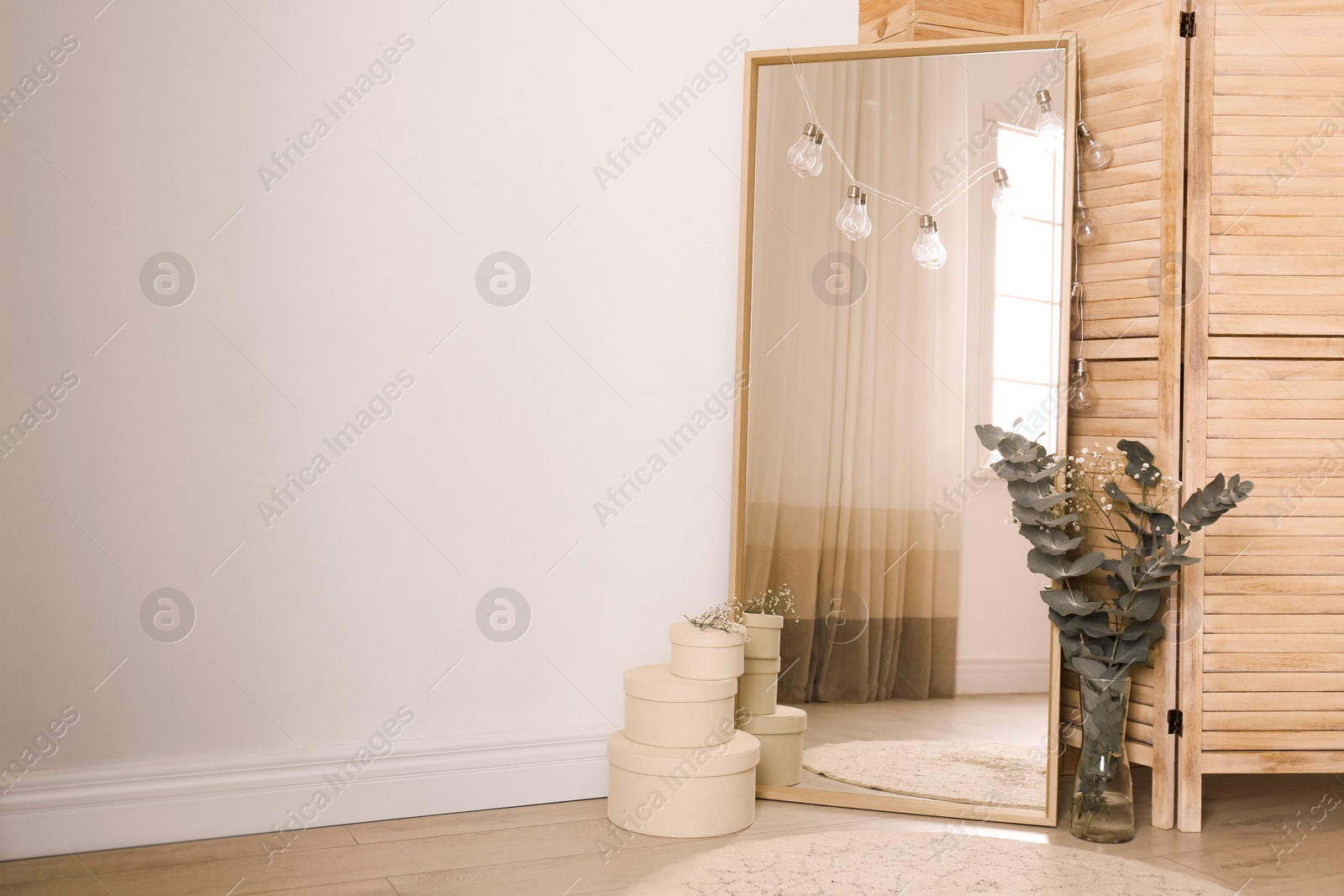 Photo of Large mirror near light wall in room. Modern interior design
