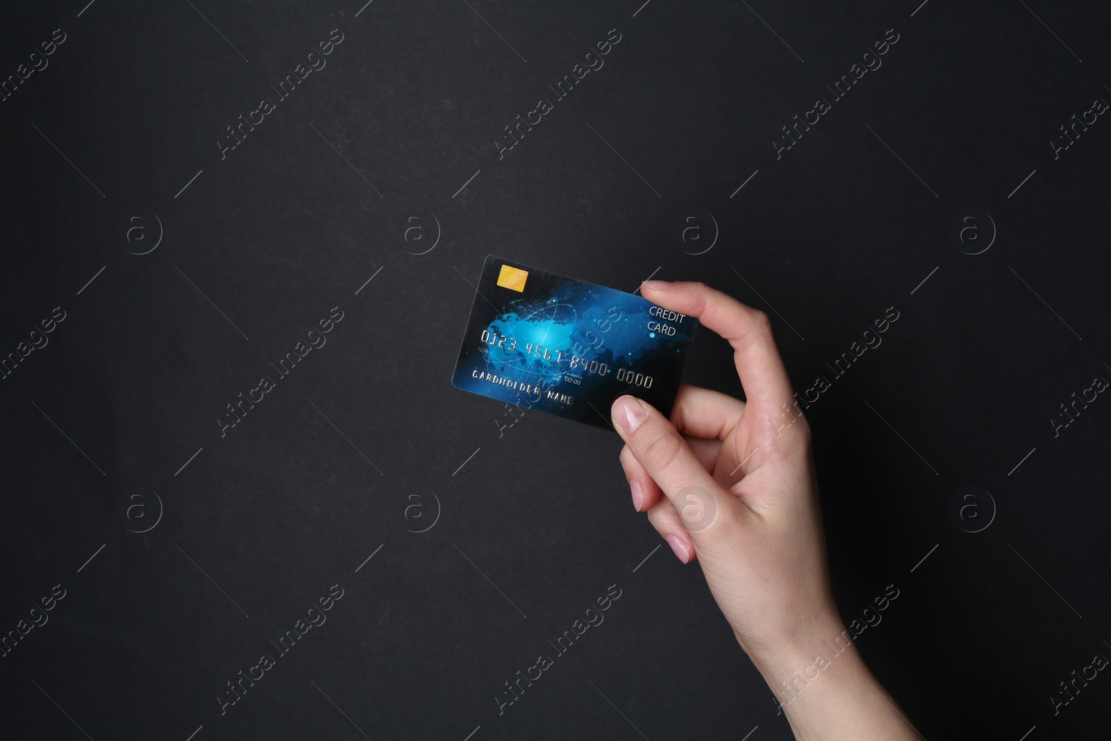 Photo of Woman holding credit card on black background, closeup