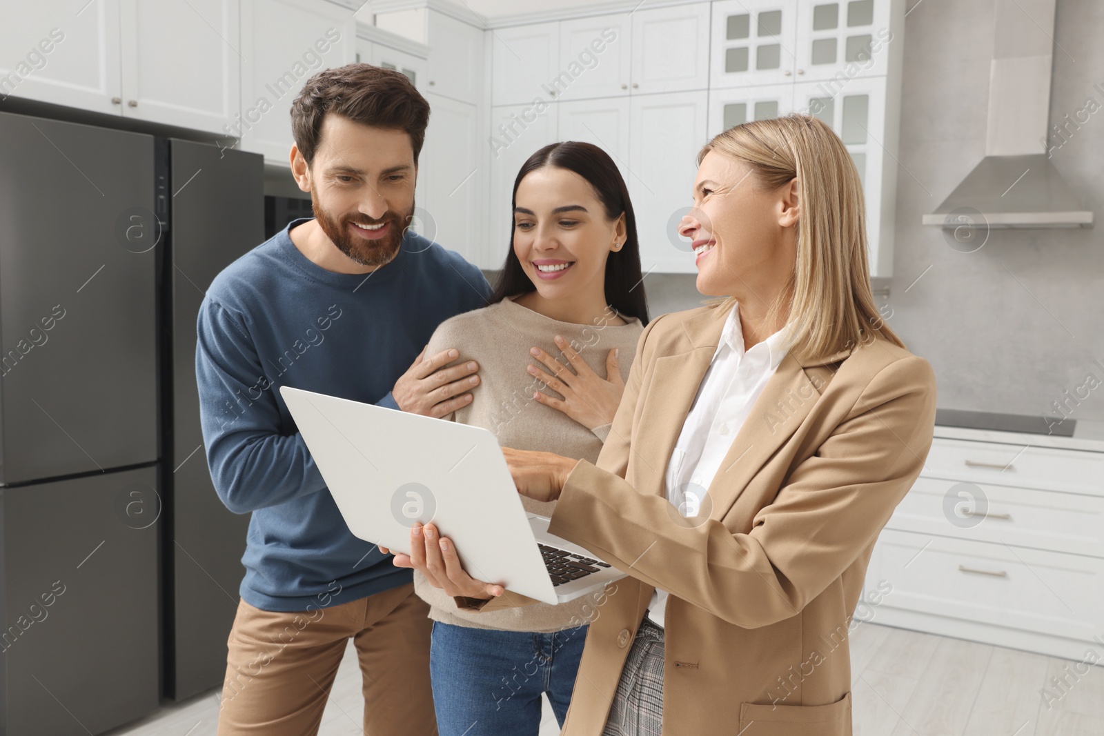 Photo of Real estate agent working with couple in new apartment