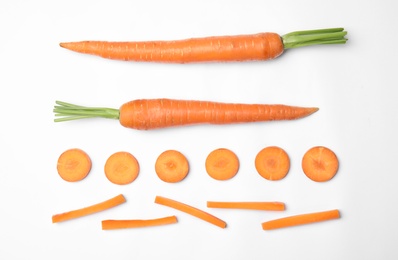 Whole and cut fresh carrots on white background