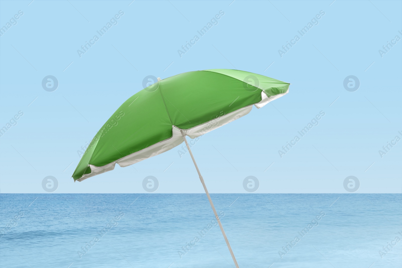 Image of Open big beach umbrella near sea on sunny day 