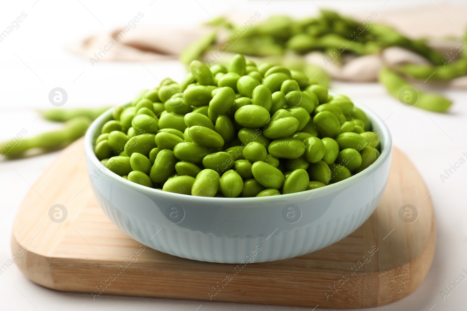 Photo of Bowl of delicious edamame beans on table