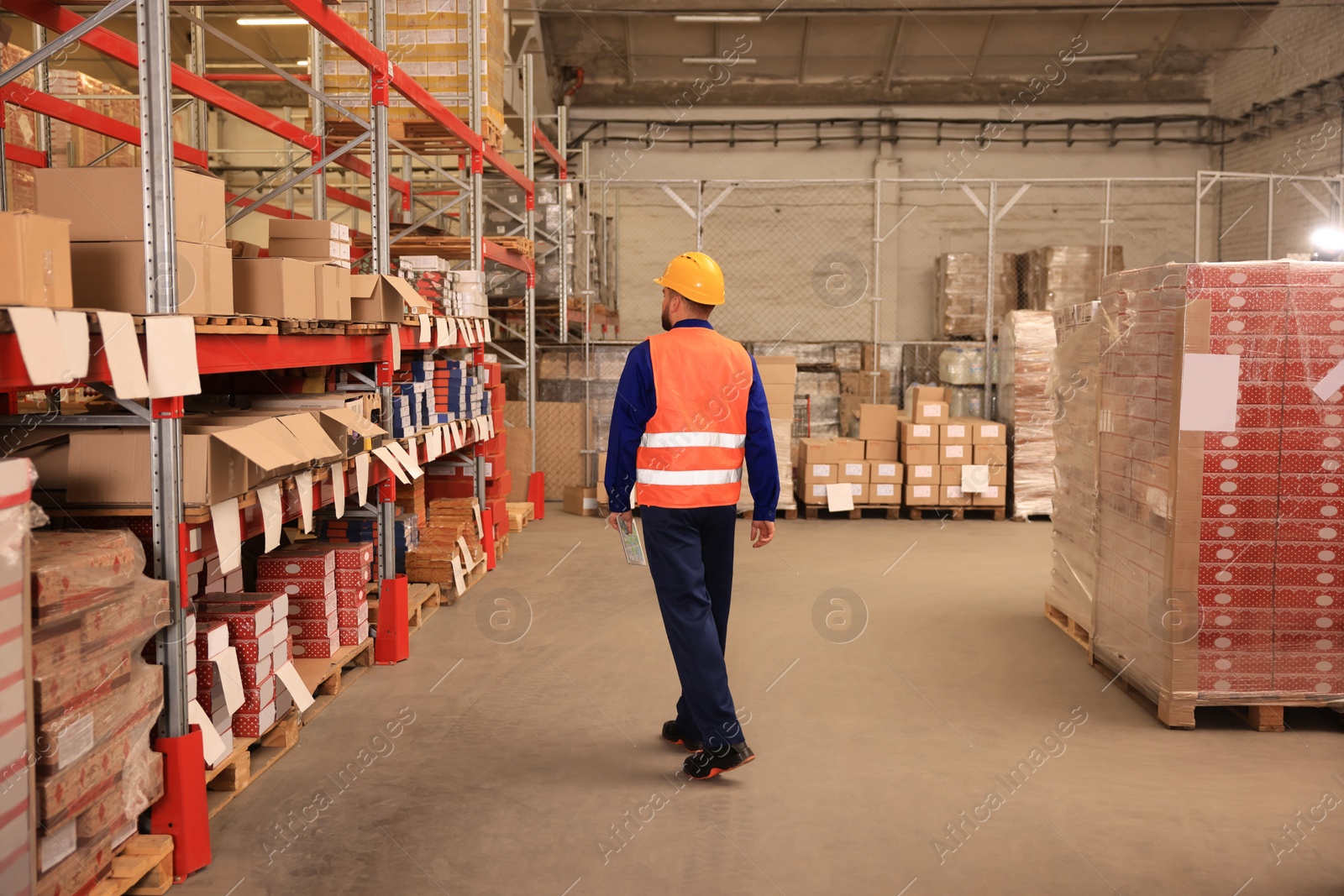 Image of Man with tablet working at warehouse, back view. Logistics center