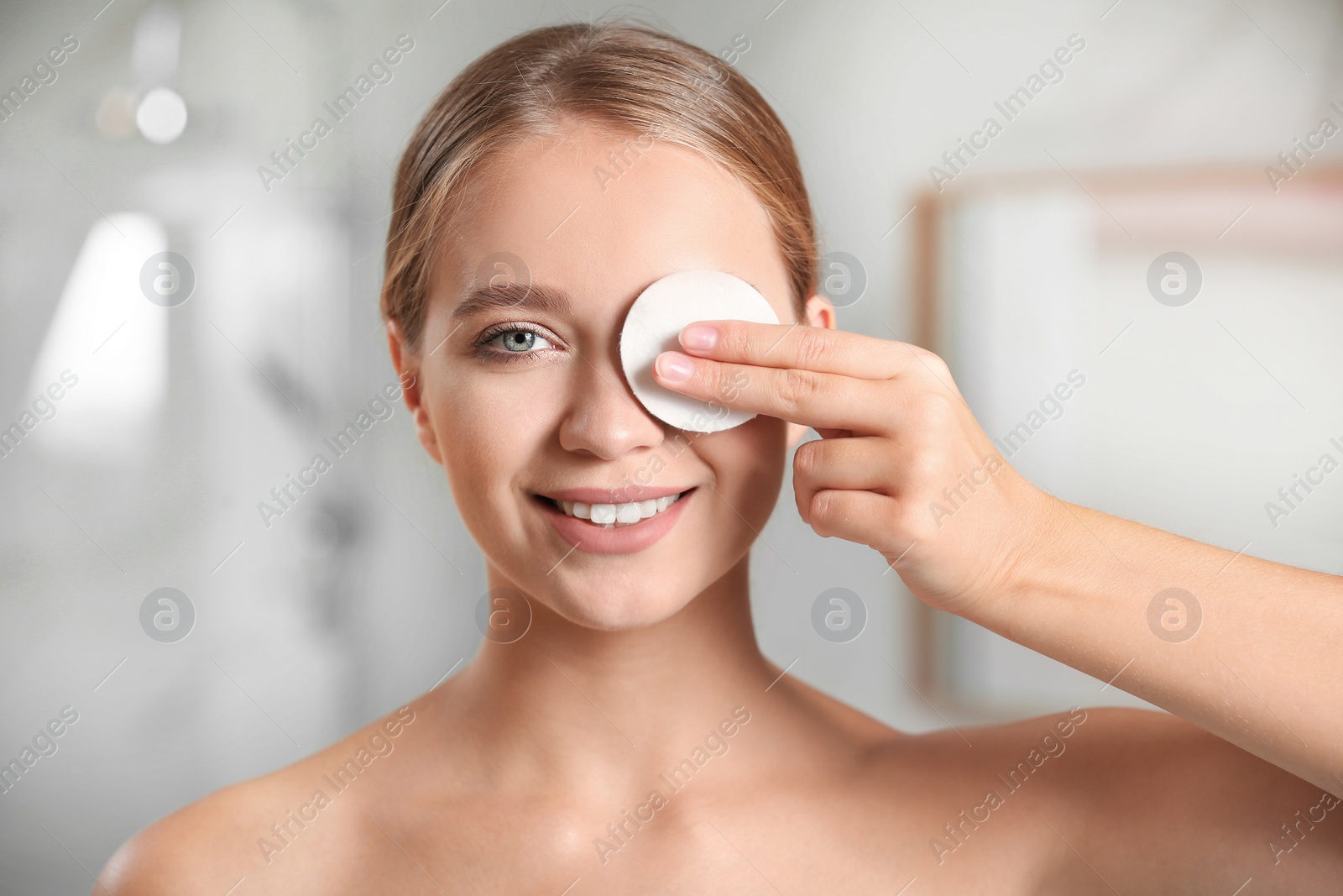 Photo of Beautiful young woman with cotton pad indoors