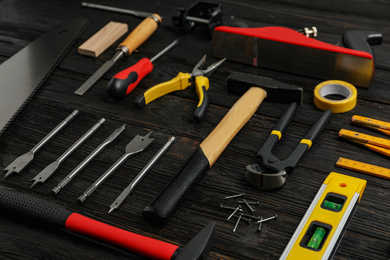 Photo of Different carpenter's tools on black wooden background