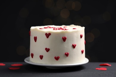 Photo of Bento cake with red cream hearts on black table. St. Valentine's day surprise