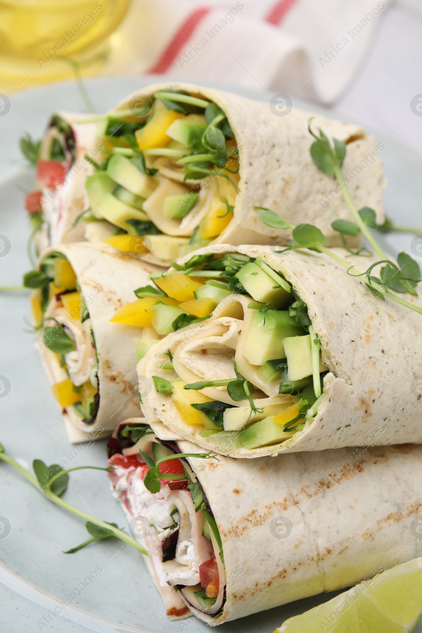 Photo of Delicious sandwich wraps with fresh vegetables on plate, closeup