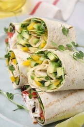Delicious sandwich wraps with fresh vegetables on plate, closeup