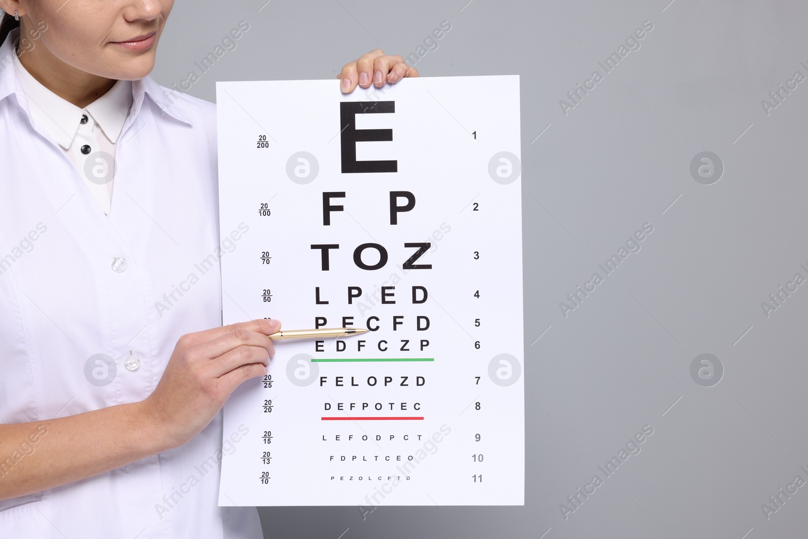 Photo of Ophthalmologist pointing at vision test chart on gray background, closeup