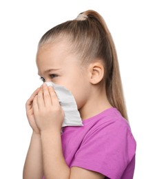 Photo of Sick girl blowing nose in tissue on white background. Cold symptoms