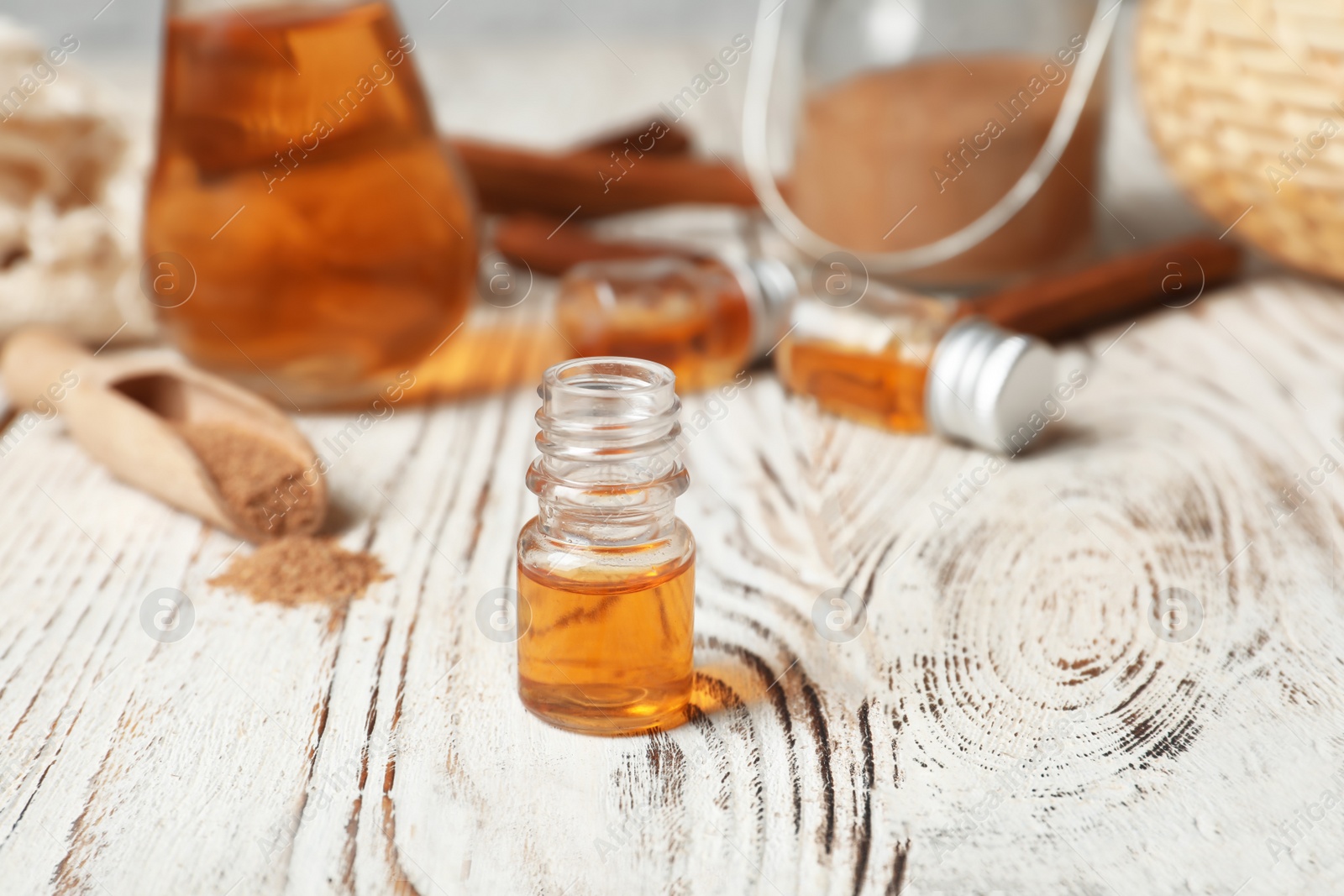 Photo of Closeup of bottle with cinnamon oil on wooden table