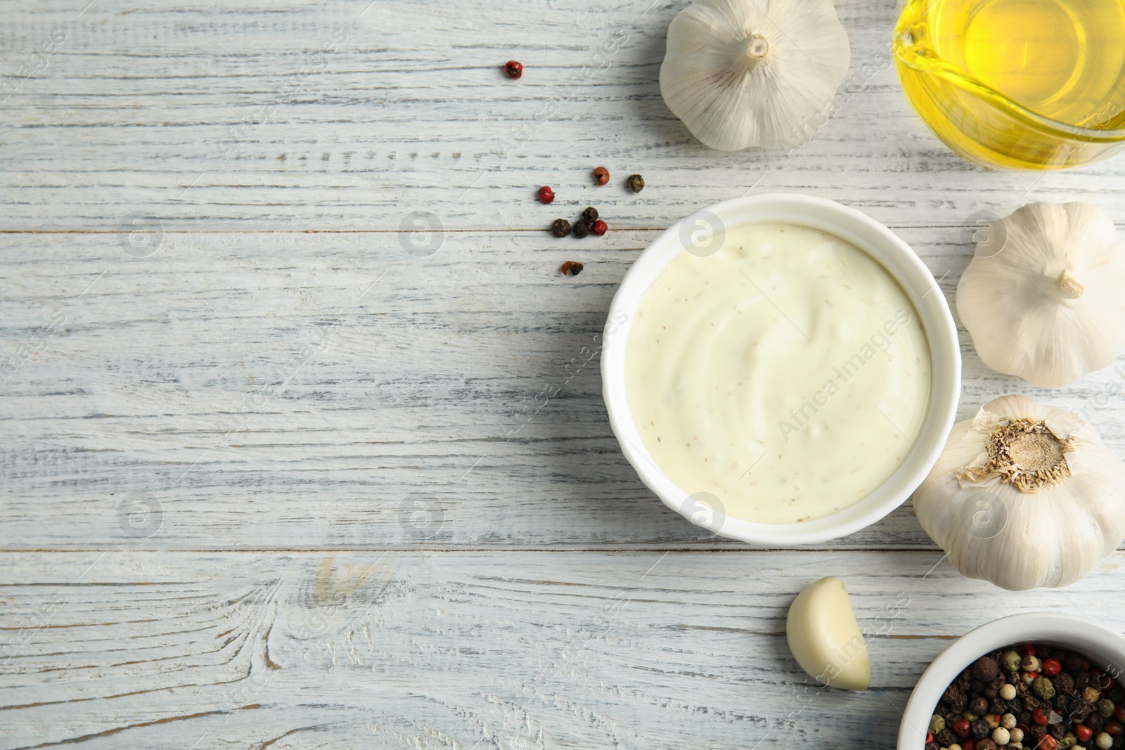 Photo of Flat lay composition with garlic sauce on white wooden background. Space for text