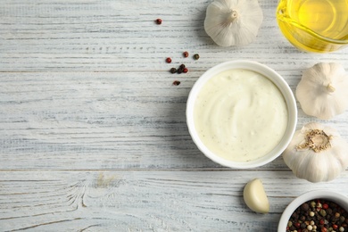 Photo of Flat lay composition with garlic sauce on white wooden background. Space for text