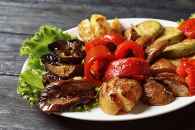 Photo of Plate with tasty grilled vegetables on table, closeup