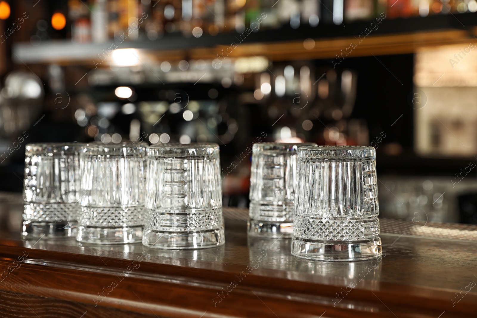 Photo of Empty clean glasses on counter in modern bar