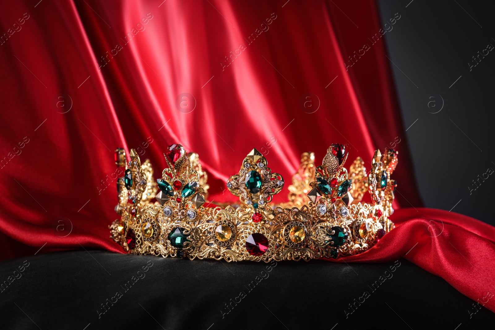 Photo of Beautiful golden crown with gems on black pillow
