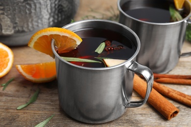 Photo of Tasty mulled wine with spices on wooden table