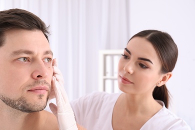 Photo of Doctor examining patient in clinic. Visiting dermatologist