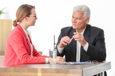 Photo of Mature man consulting with woman in office