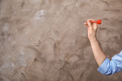 Photo of Woman holding dart on color background. Business trainer concept