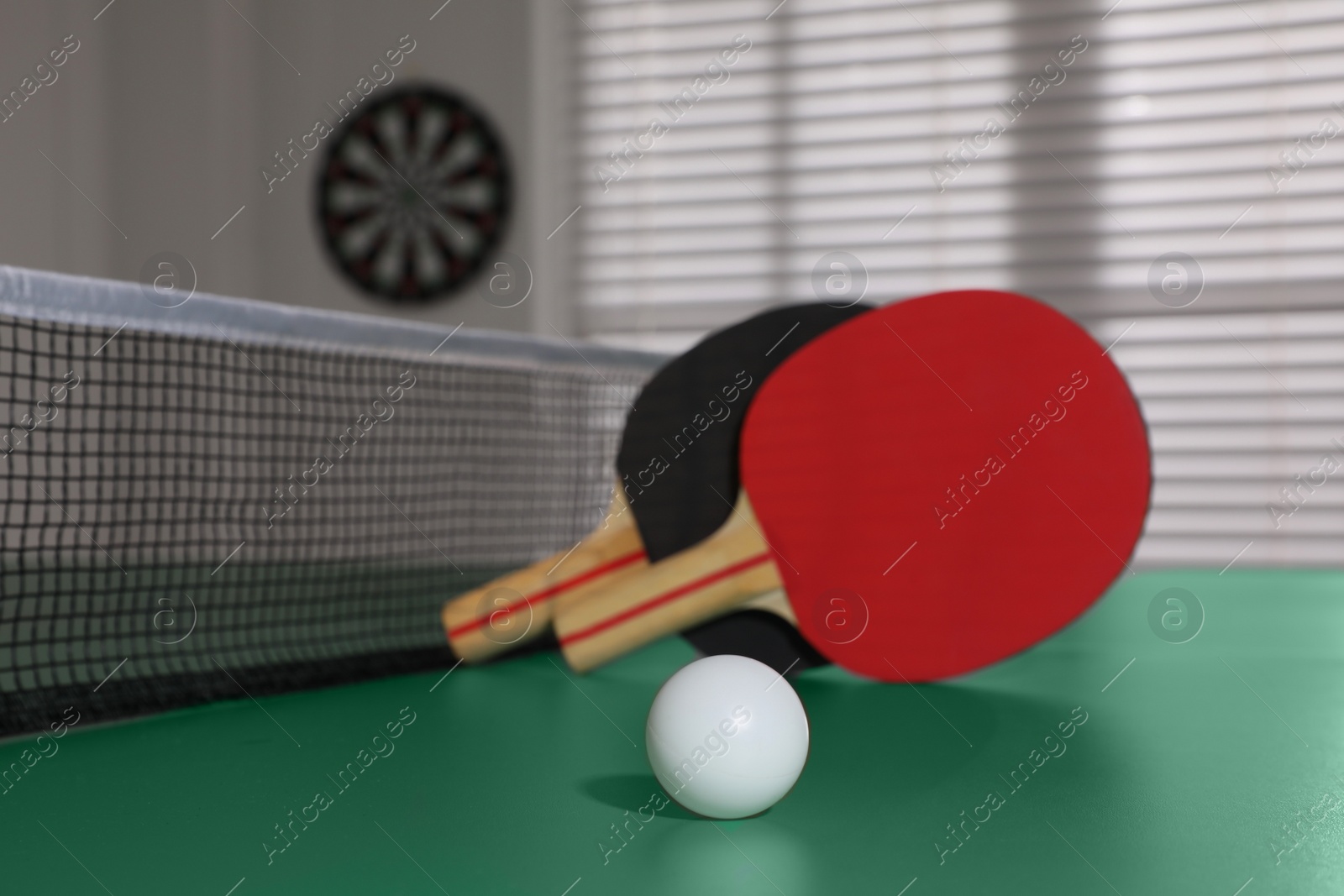 Photo of Rackets and ball on ping pong table indoors