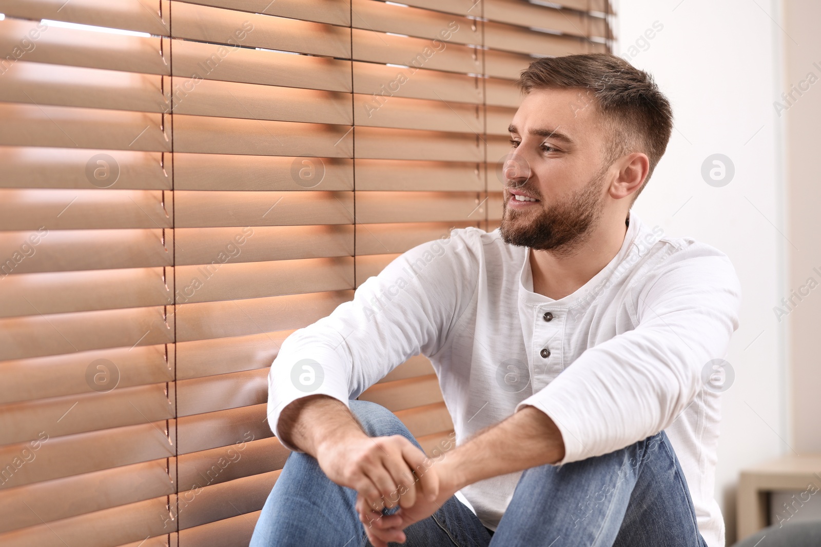 Photo of Handsome young man near window at home