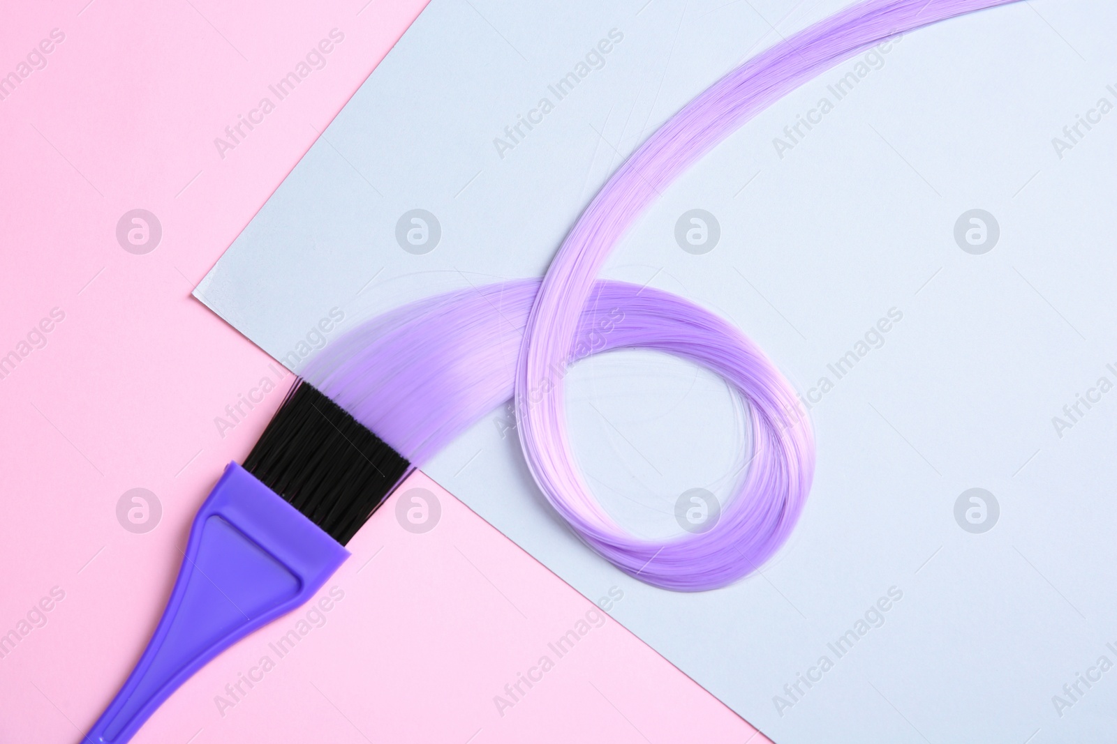 Photo of Flat lay composition with strand of hair and brush on color background