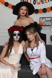 Photo of Group of women in scary costumes indoors. Halloween celebration