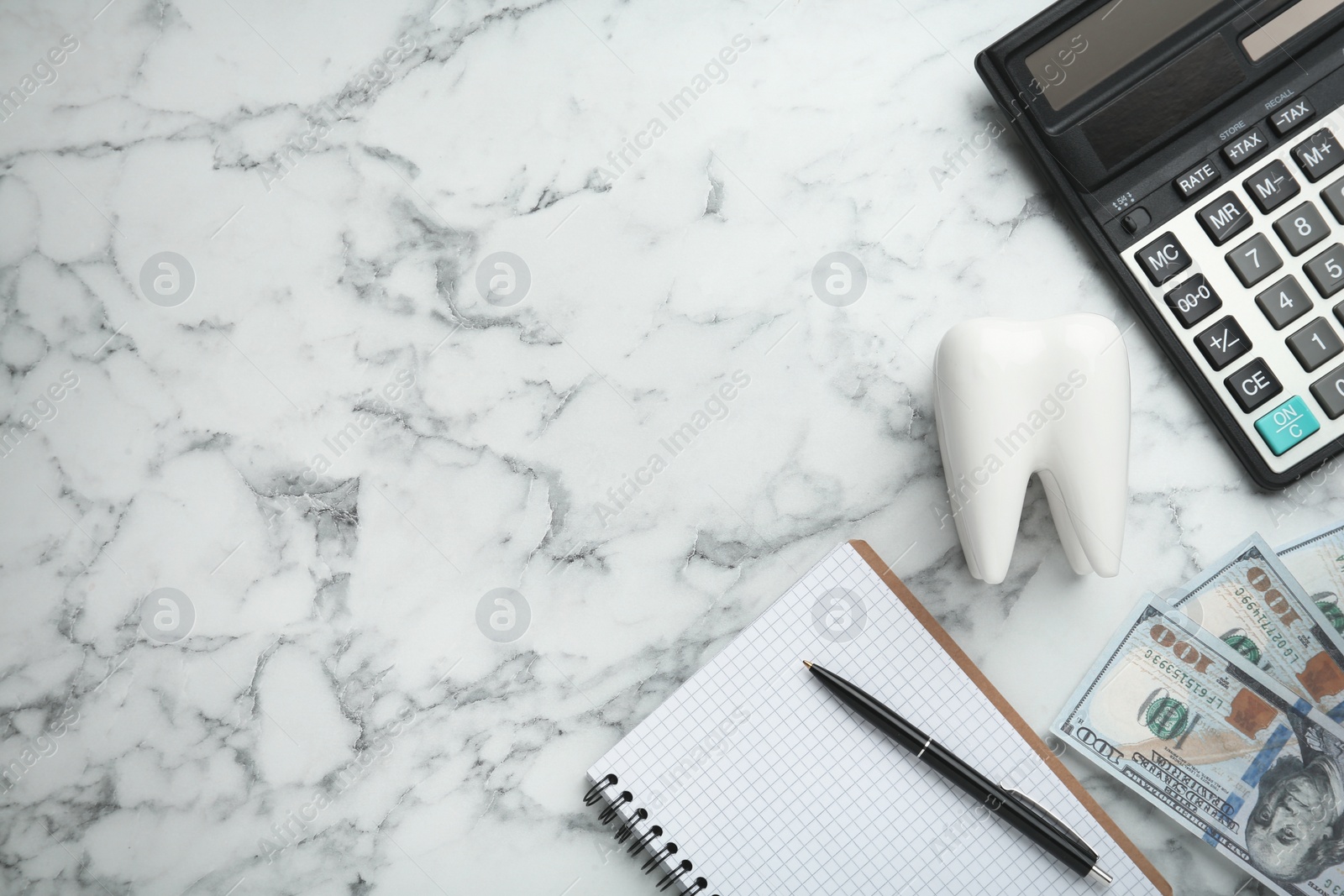 Photo of Flat lay composition with ceramic model of tooth and money on white marble table, space for text. Expensive treatment