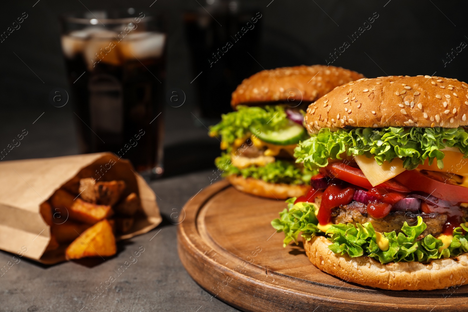 Photo of Tasty burgers and fried potatoes on table. Space for text