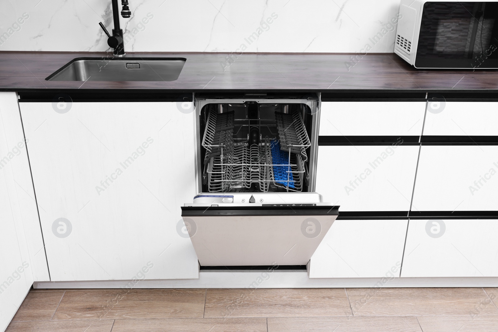 Photo of Built-in dishwasher with open door in kitchen