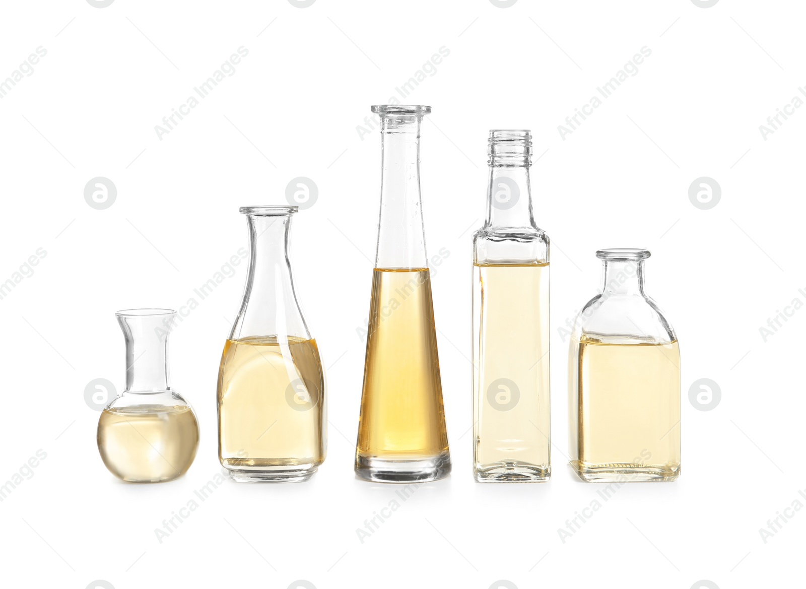 Photo of Row of different glass bottles with oil on white background