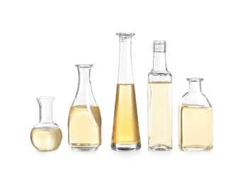 Row of different glass bottles with oil on white background