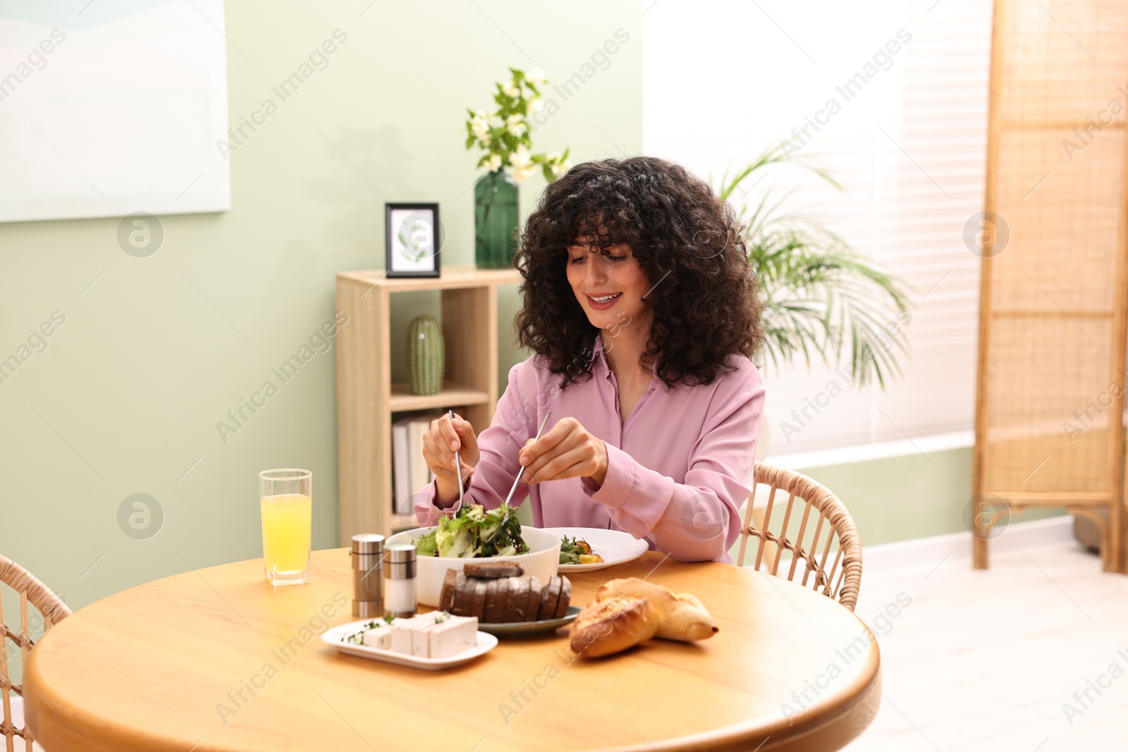 Photo of Woman having vegetarian meal at table in cafe