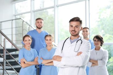 Photo of Portrait of male doctor and his colleagues at workplace