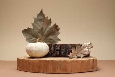Photo of Autumn presentation for product. Wooden stumps, leaves and pumpkin on color background
