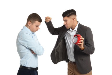 Businessman with alarm clock scolding employee for being late on white background