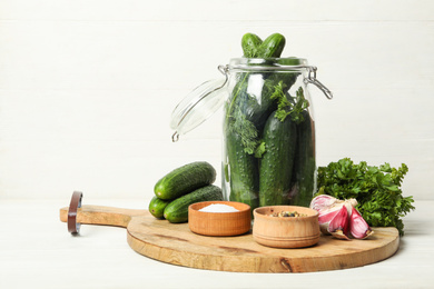 Photo of Pickling jar with fresh ripe cucumbers and spices on white wooden table
